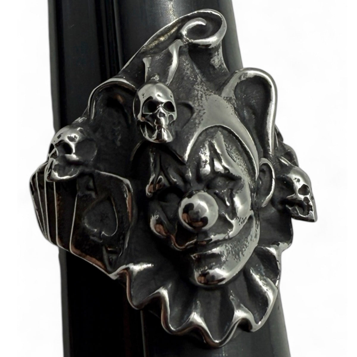 Front view of sinister killer clown ring with skulls and jester hat – gothic biker jewelry statement piece
