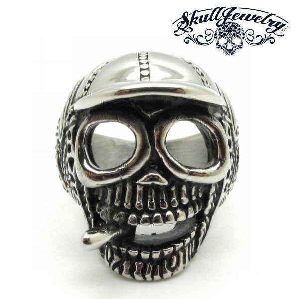 baseball cap wearing skull ring smoking a cigar