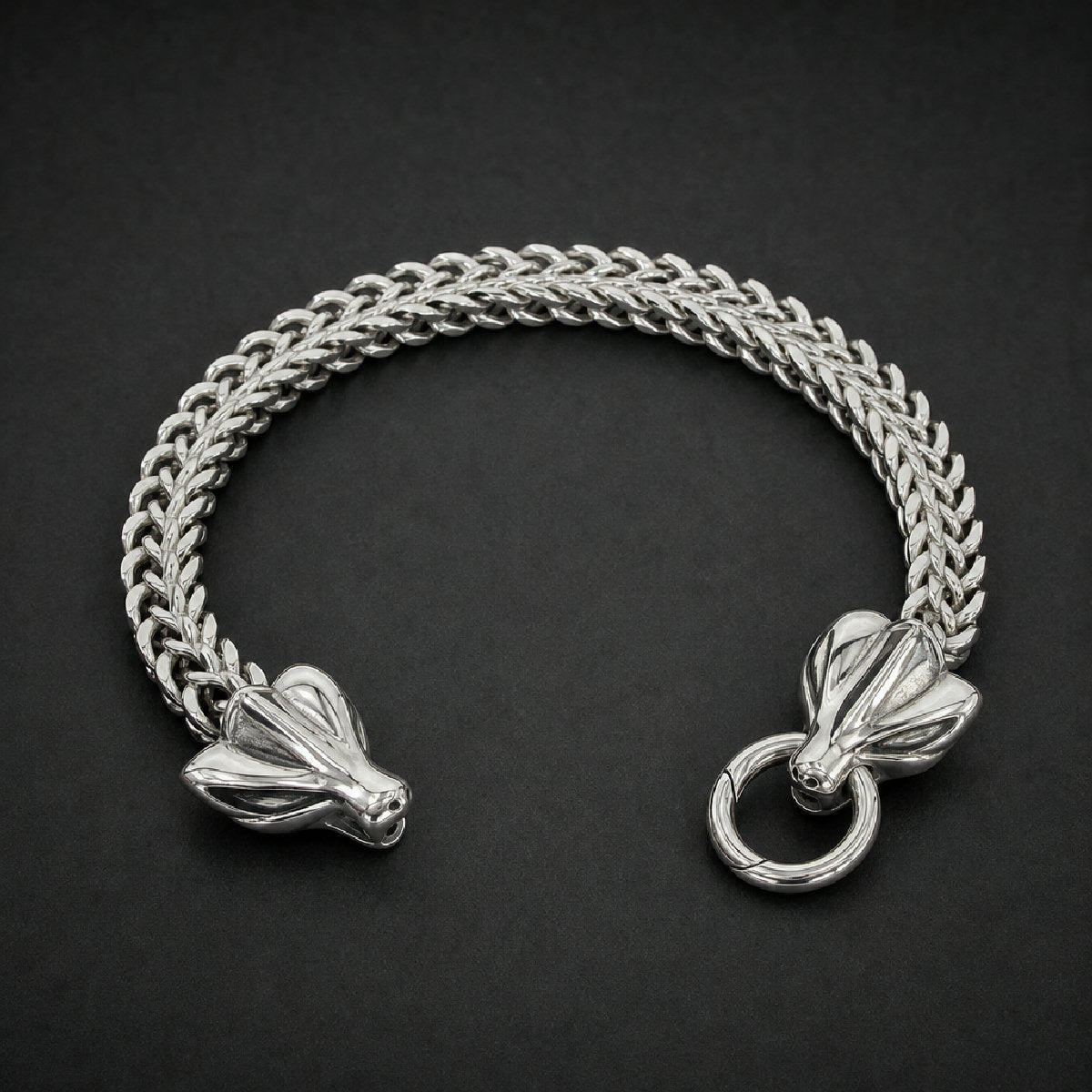 Heavy 316L stainless steel bone link bracelet with polished beast head clasp on a wooden table, silver color