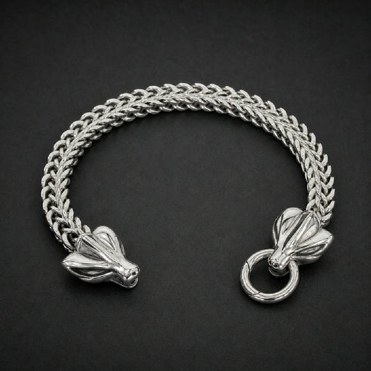Heavy 316L stainless steel bone link bracelet with polished beast head clasp on a wooden table, silver color