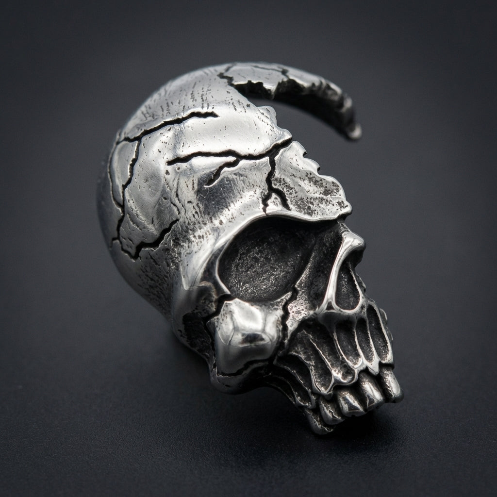 Cracked skull pendant made from 316L stainless steel, featuring dark silver oxidized crevices and a rugged textured finish, a fierce biker emblem.