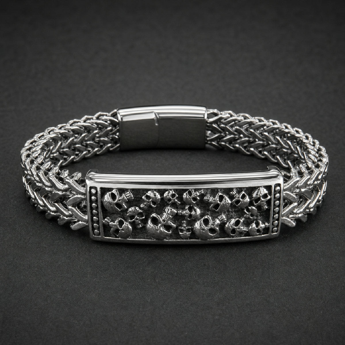 Cranium Vault Bracelet, heavy-duty 316L surgical stainless steel, wide woven chain, central rectangular plaque with detailed skull cluster, polished finish.