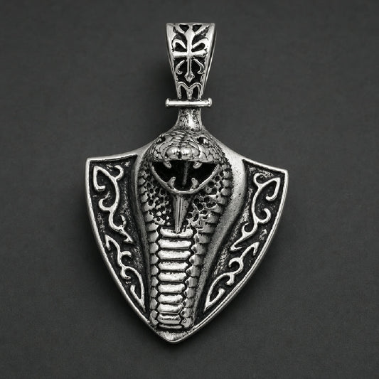 Solid 316L stainless steel cobra pendant featuring a striking snake with open fangs on an arrowhead shield with an ornate carved bail