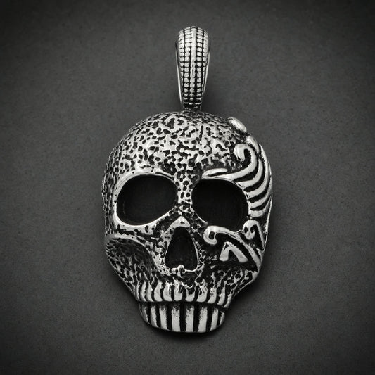 Damnatio Cranium Pendant in 316L surgical stainless steel featuring pitted skull texture and polished filigree eye scrollwork