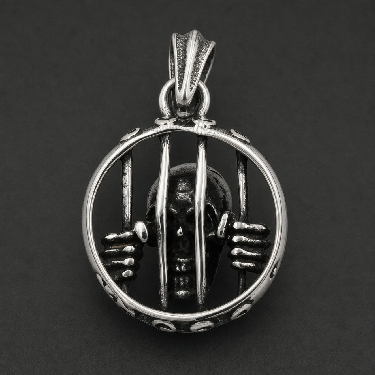 Solid 316L surgical stainless steel pendant featuring a detailed skull trapped behind circular prison bars with skeletal hands gripping the cage