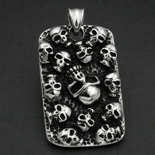 Solid 316L stainless steel dog tag pendant covered with multiple high-relief skulls against an antiqued hammered black surface