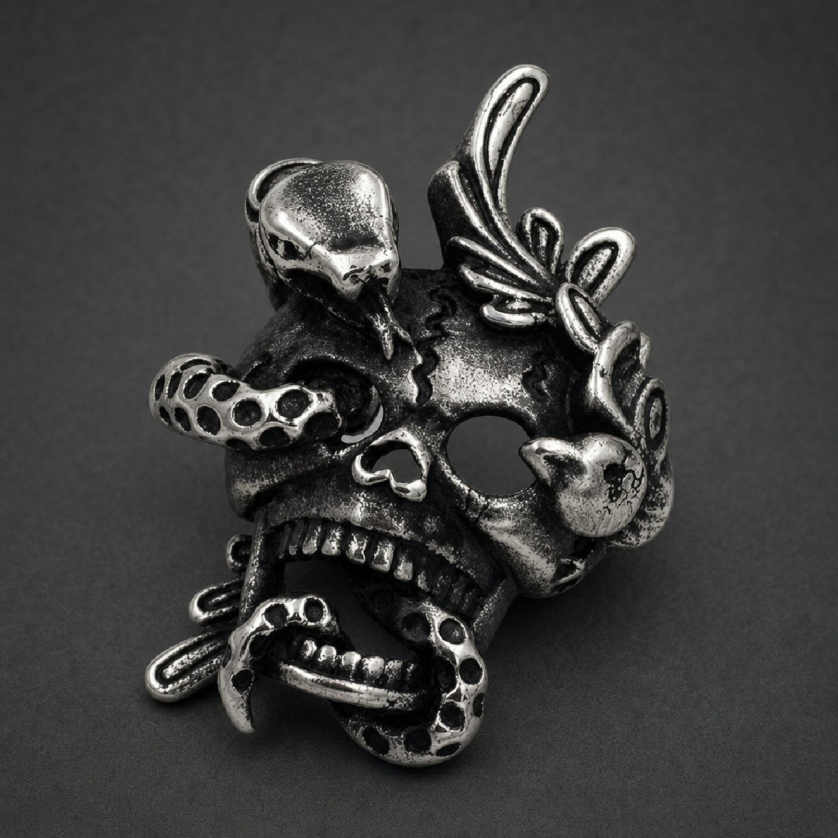 Antiqued 316L stainless steel pendant featuring a cracked cranium entwined with a coiled snake through its jaw and eye socket.