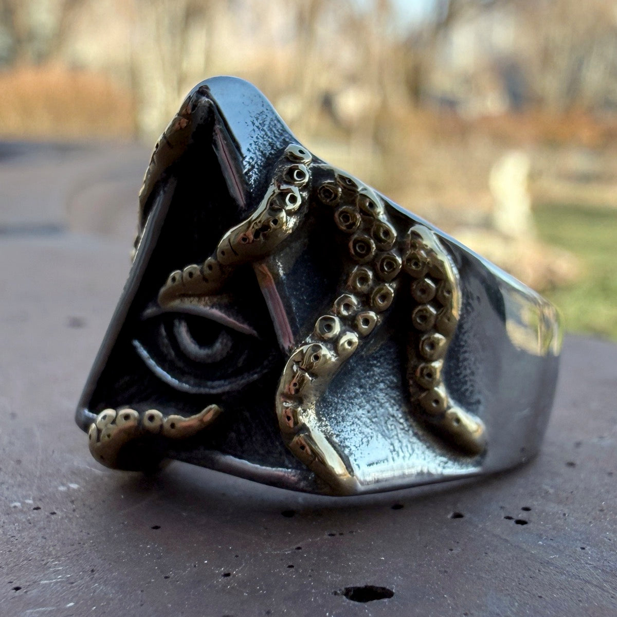 Stainless steel pyramid ring featuring a recessed eye and gold details