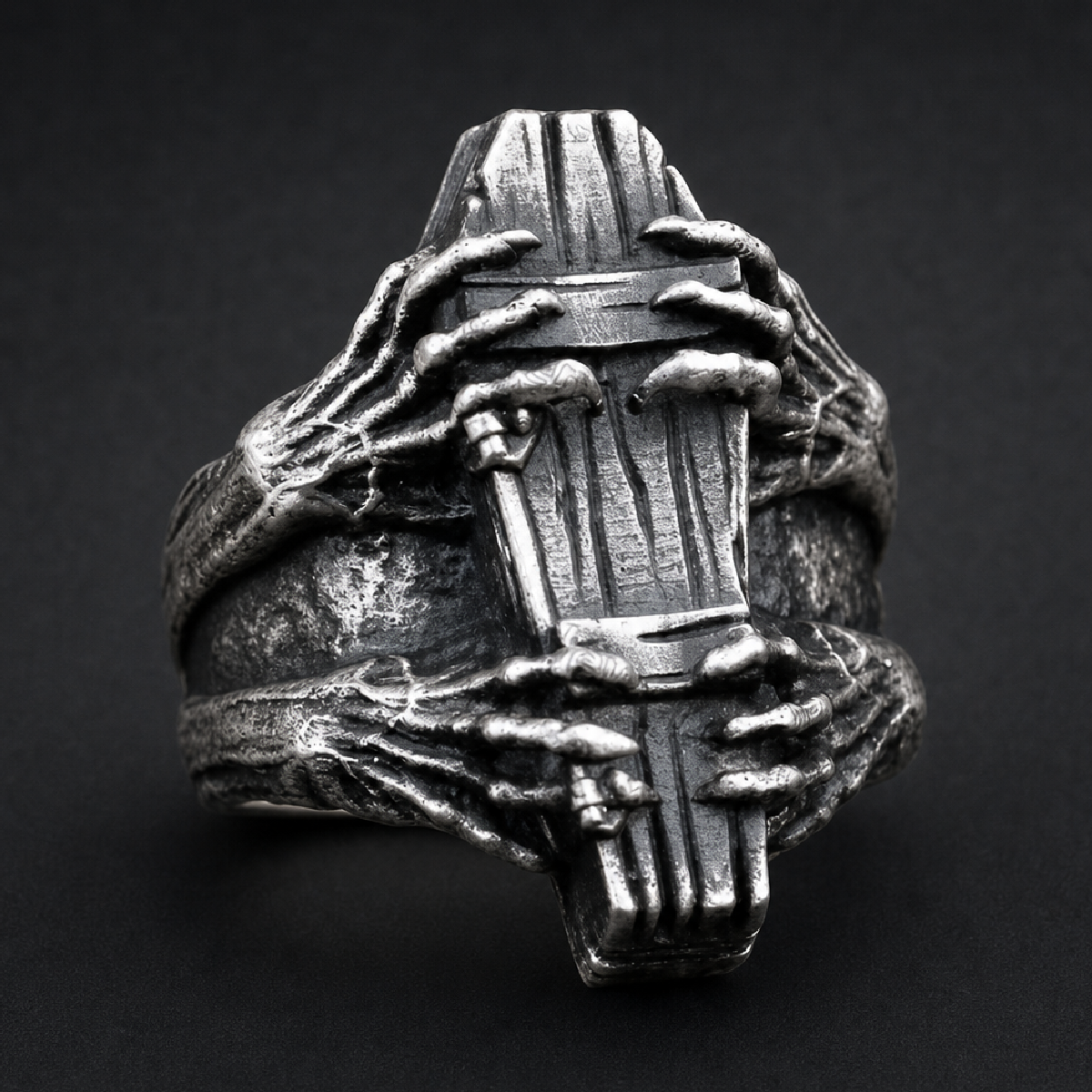 Silver 316L stainless steel Dead Man's Hold ring featuring skeletal hands clutching a coffin, with an antique, oxidized finish.