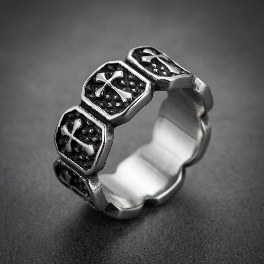 Heavy 316L stainless steel ring with repeating raised cross motifs on a textured dark background