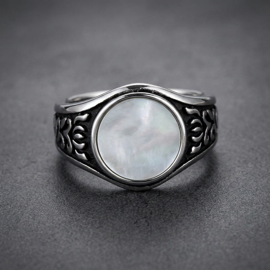 HardKnocker 316L stainless steel ring with a central iridescent mother-of-pearl style panel, framed by a high-polish bezel. The ring band features deep, dark, etched flowing patterns on both sides, with a polished wave-like top and bottom edge.