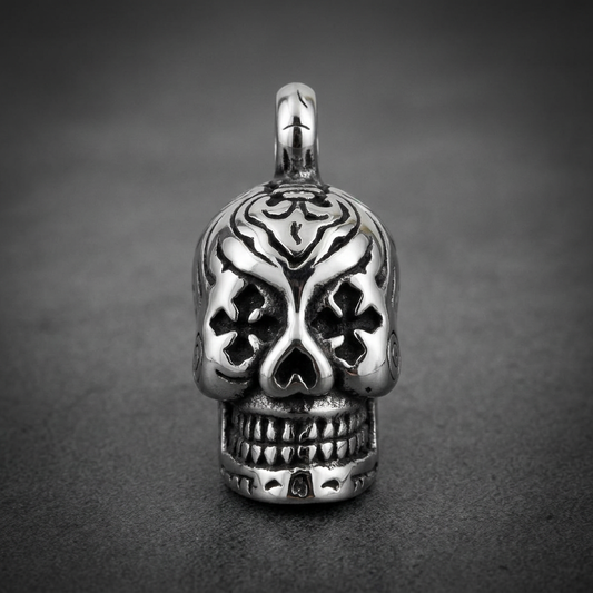 Ornate skull pendant in polished and blackened 316L surgical stainless steel with intricate tribal patterns on top and deep-set eyes.
