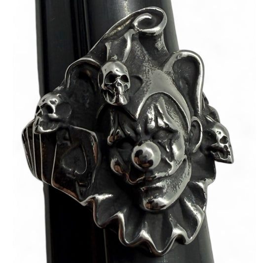 Front view of sinister killer clown ring with skulls and jester hat – gothic biker jewelry statement piece