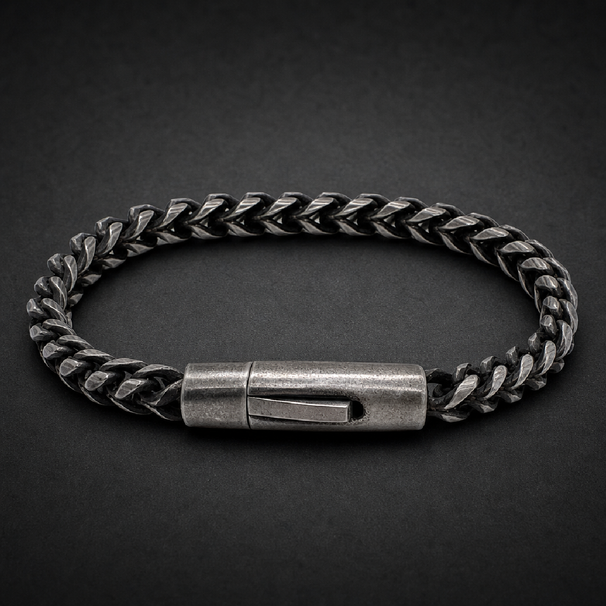 Heavy 316L stainless steel brutalist wheat chain bracelet with secure barrel clasp in a dark, aged silver finish on a black background.