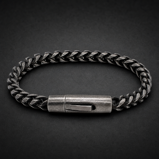 Heavy 316L stainless steel brutalist wheat chain bracelet with secure barrel clasp in a dark, aged silver finish on a black background.