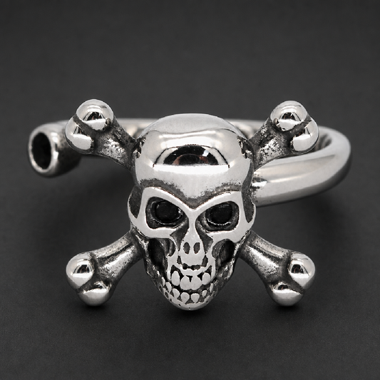 Shiny 316L surgical stainless steel unisex ring featuring a prominently detailed skull with black eye sockets and two crossbones behind it, set on a solid band with an antiqued finish in the recessed areas, showcasing a heavy and durable design.