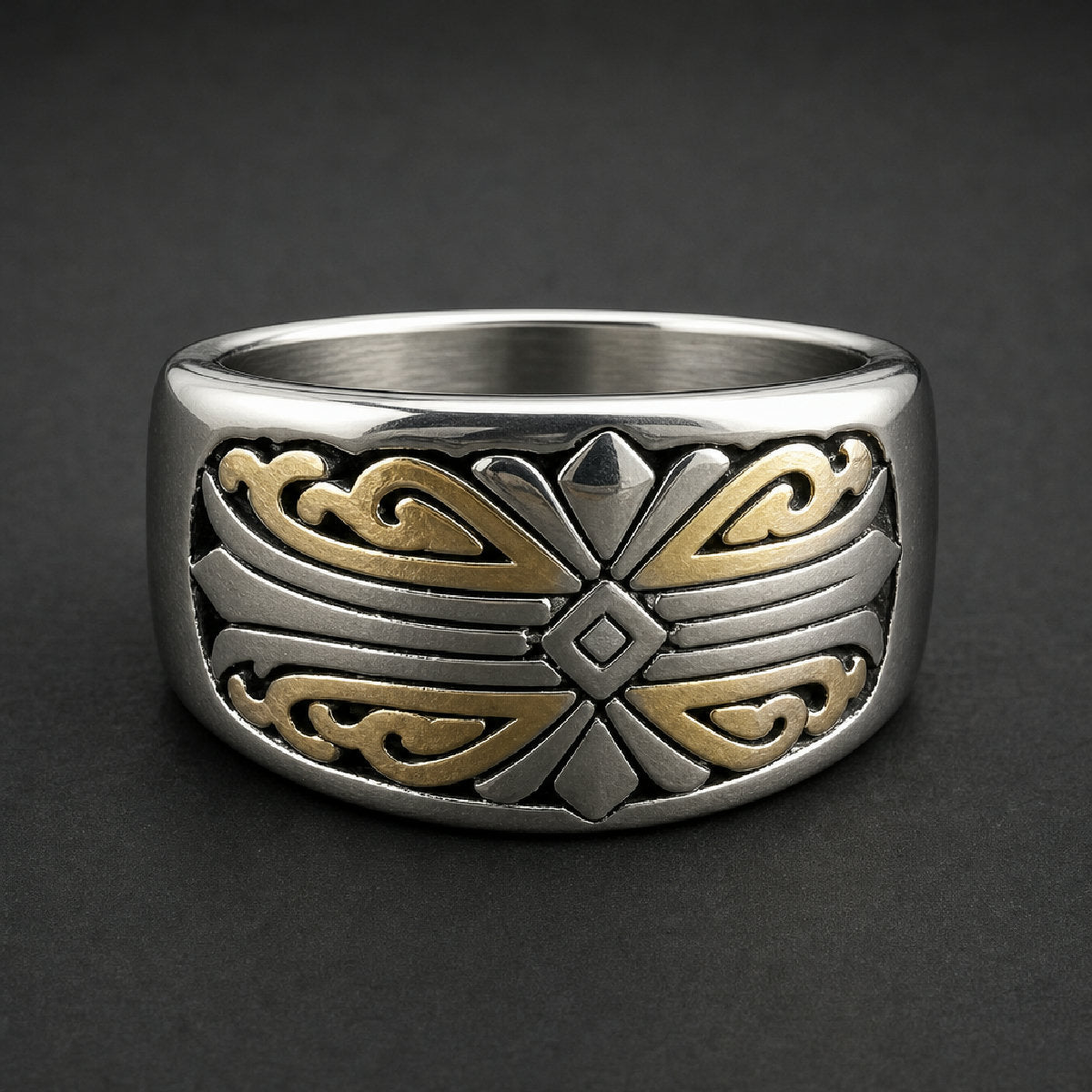 Heavy two-tone gold and silver 316L stainless steel ring with intricate script pattern on a wooden surface.
