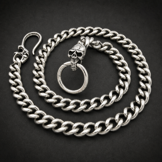 Heavy 316L stainless steel Cuban link wallet chain with two skull motifs, one on the spring gate ring attachment and one on the clasp, against a white background.