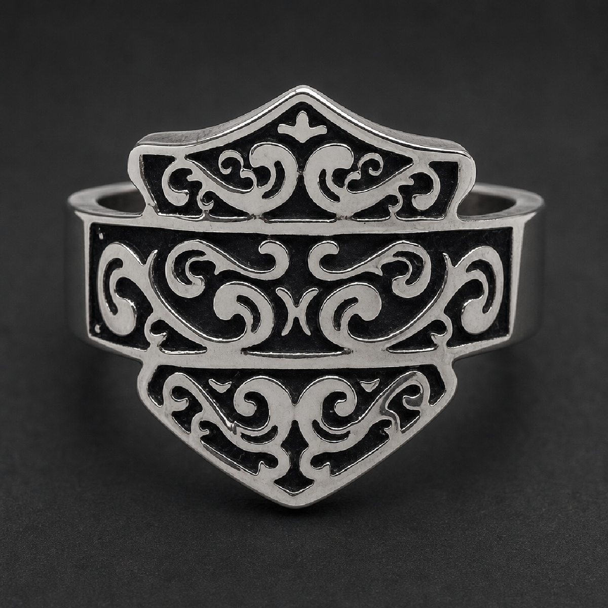 Close-up of The Iron Crest Scroll Ring, a bold shield-shaped ring crafted from 316L surgical stainless steel with intricate dark scrollwork.