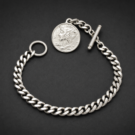 Heavy 316L stainless steel cuban link chain bracelet with a large round silver medallion featuring a profile of a face, secured by a toggle clasp.