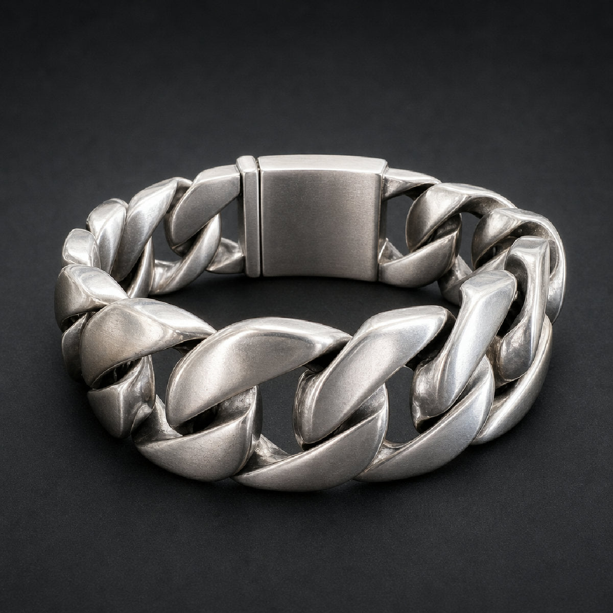 Heavy-duty 316L stainless steel wide curb link bracelet with a brushed finish and substantial box clasp, shown on a rustic wooden surface.