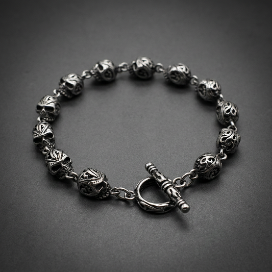 Silver 316L surgical stainless steel skull bracelet with detailed filigree patterns and a toggle clasp.