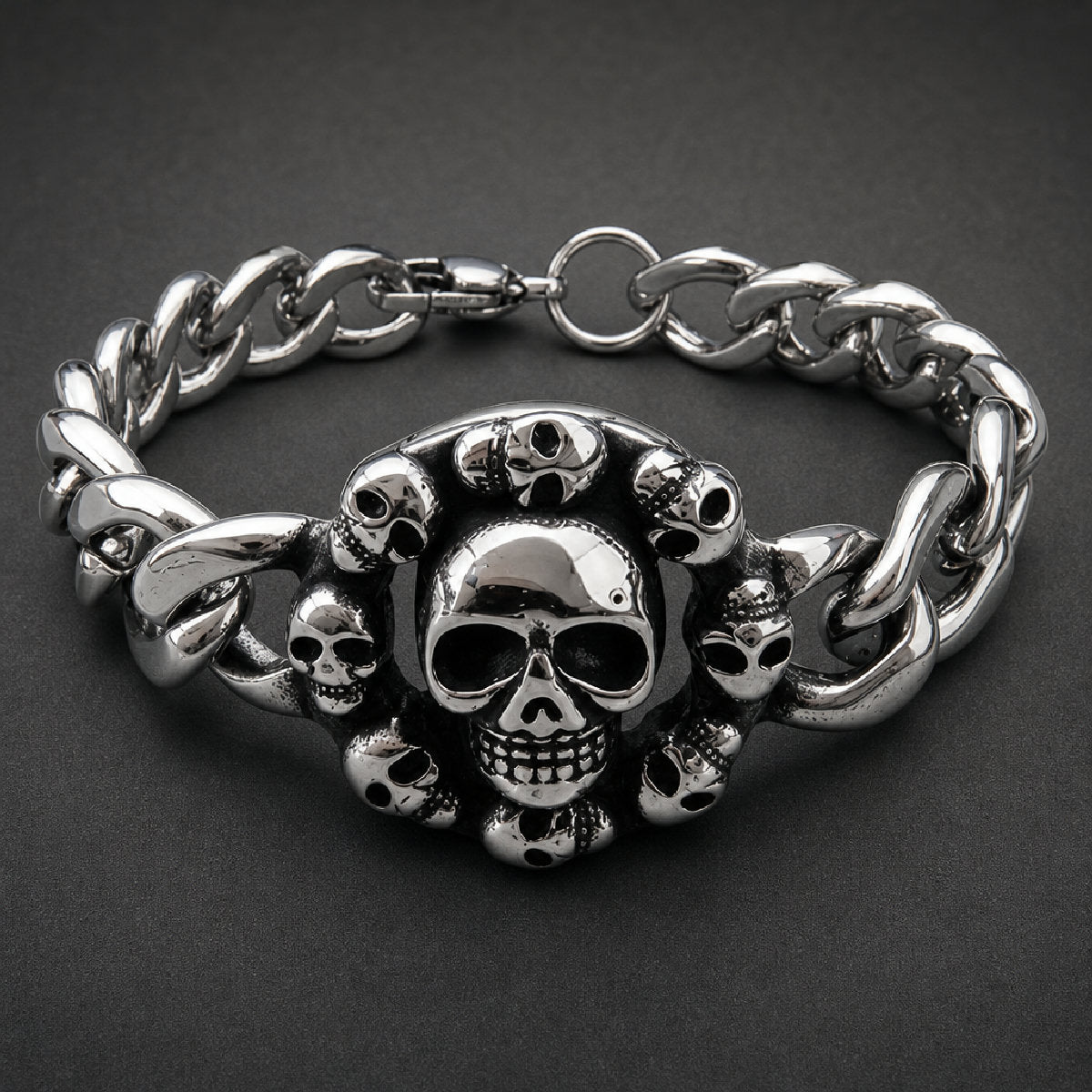 316L stainless steel skull bracelet featuring an oval halo of mini skulls surrounding a large center skull on curb links