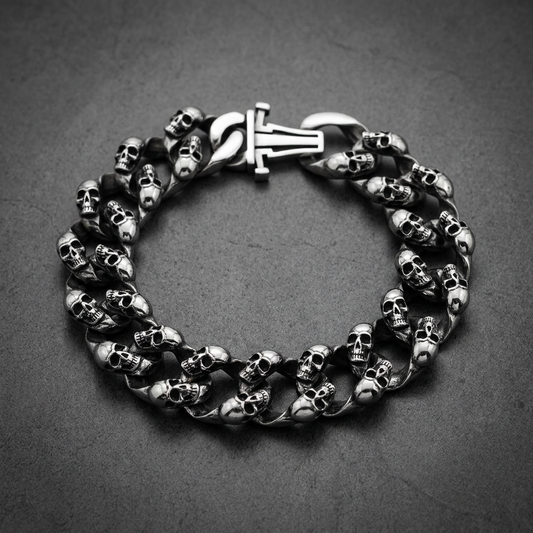 Thick 316L stainless steel bracelet featuring numerous detailed skulls on each link, with a larger skull on the rectangular clasp, in dark silver.