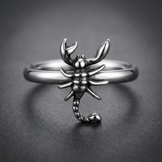Scorpion HardKnocker 316L stainless steel ring, featuring a detailed, textured scorpion with prominent claws and a curled, barbed tail, set on a smooth, wide band, against a light, reflective background.