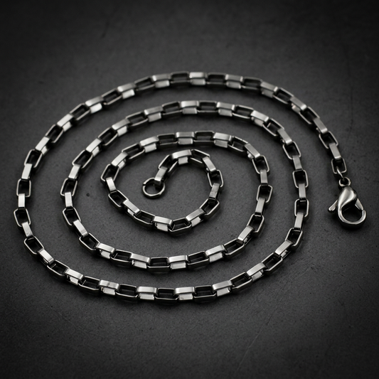 Eternal Box Chain necklace made of polished 316L surgical-grade stainless steel with classic box links, lying on a dark background.
