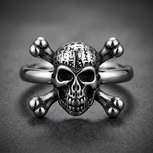 A 316L stainless steel unisex ring featuring a bold skull and crossbones motif. The skull has dark eye sockets and a textured cranium, resting on polished crossbones, all in a silver finish.