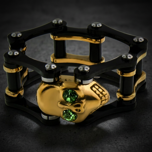 HardKnocker black and gold 316L stainless steel unisex ring with an industrial design, featuring a gold skull, green gemstone eyes, and bold contrast elements.