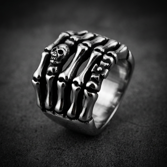 Bone Grasp skull ring made of 316L stainless steel, featuring two skeletal hands clenching a prominent central skull.