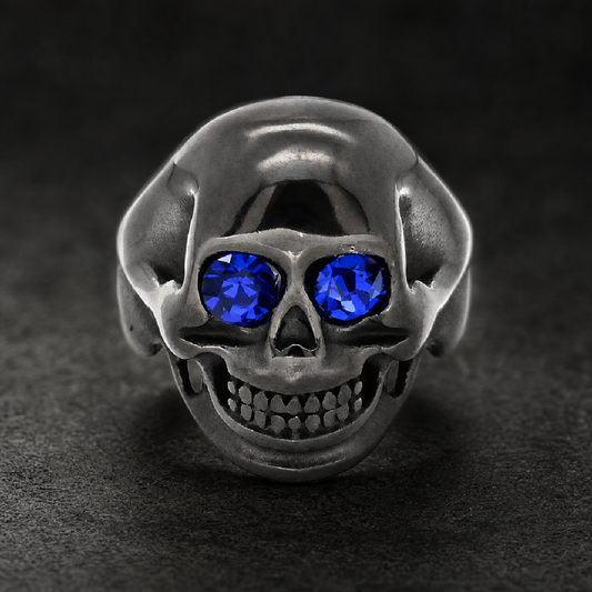 Bold HardKnocker black oxidized 316L surgical-grade stainless steel skull ring with two vivid blue gemstone eyes.