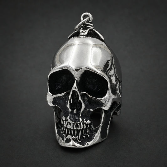 Solid 316L stainless steel skull pendant with blackened eye sockets and mirror polished finish.
