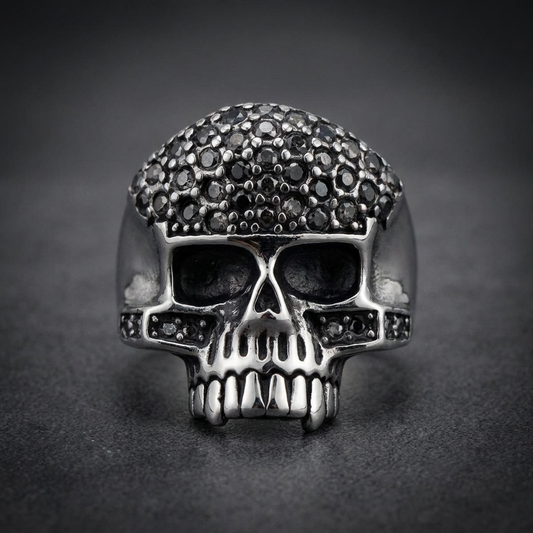 Black-paved skull ring made from 316L stainless steel, featuring dark stones covering the skull's cranium and eyes.