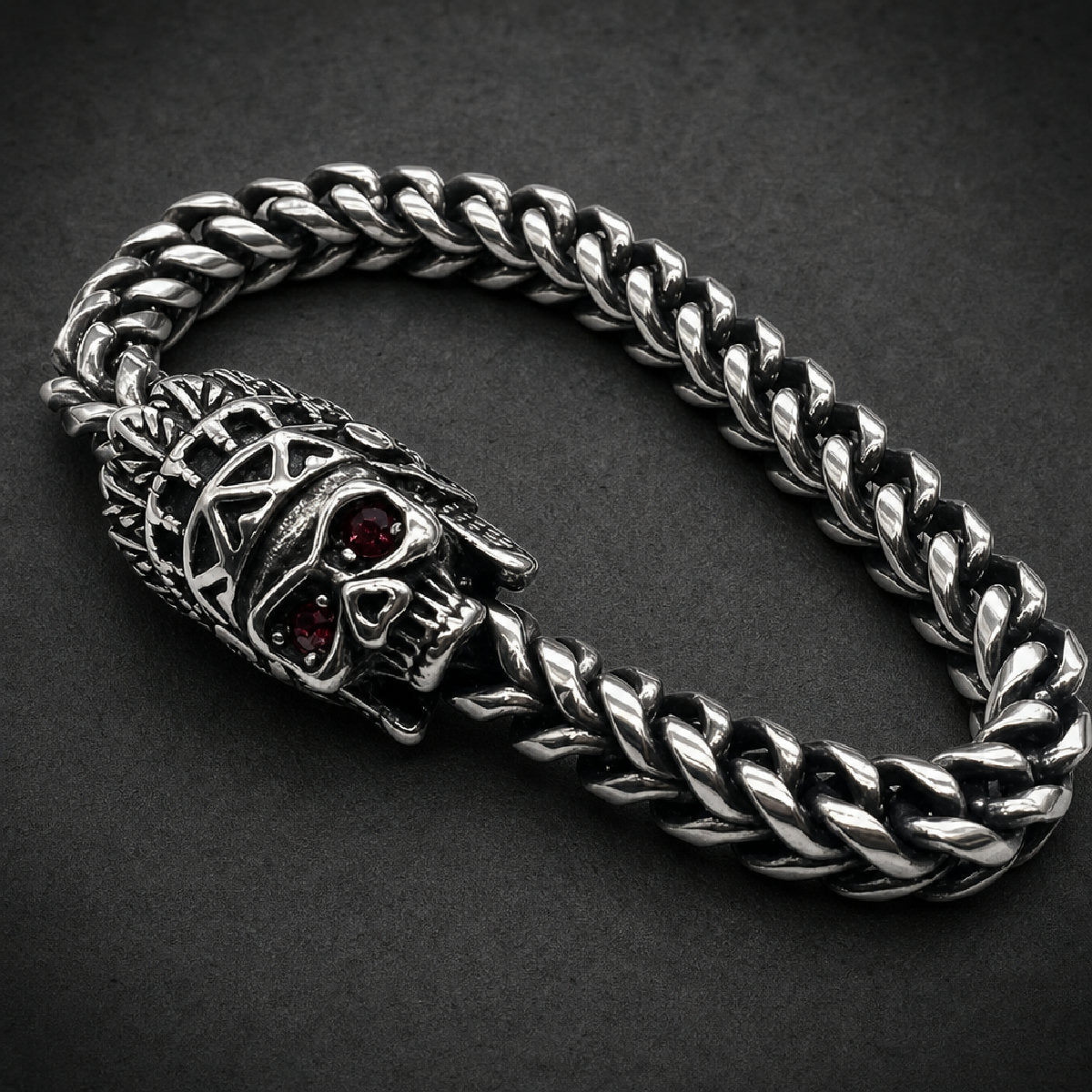 316L stainless steel warbonnet skull bracelet featuring faceted red gemstone eyes and an oxidized braided wheat chain