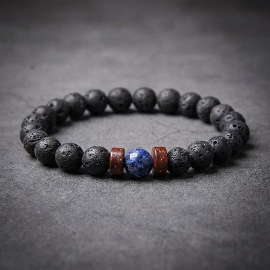 Black lava rock bead bracelet with a central blue lapis lazuli bead and brown wood barrel spacers, crafted from 316L stainless steel.