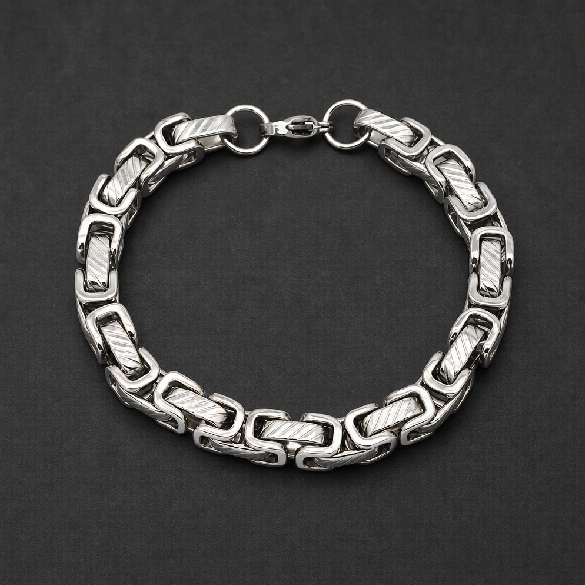Thick heavy polished 316L stainless steel bar link bracelet with intricate textured rectangular segments connected by smooth round links, secured by a lobster clasp.